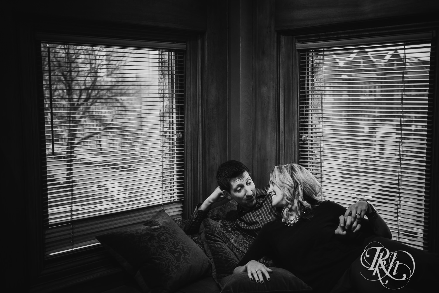 Man in flannel and woman in black shirt smile during Van Dusen Mansion engagement photography.