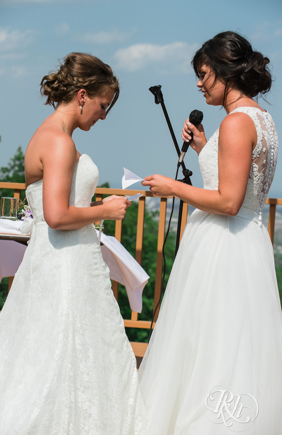 Lesbian brides read vows during outdoor ceremony at Spirit Mountain in Duluth, Minnesota.