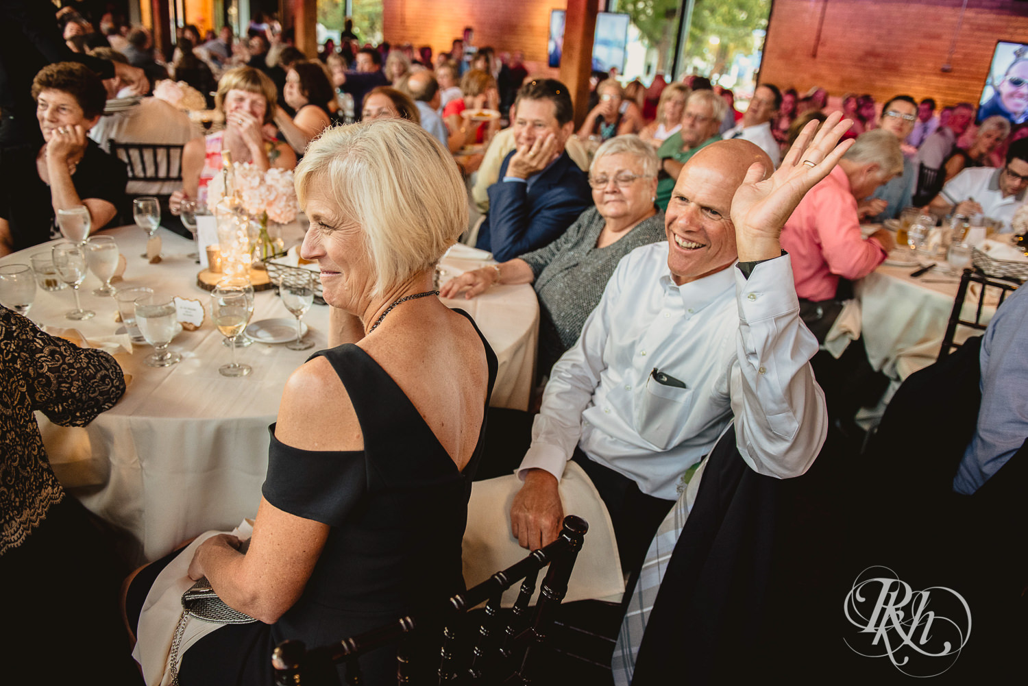 Guests smile during wedding speeches at Minneapolis Event Centers in Minneapolis, Minnesota.