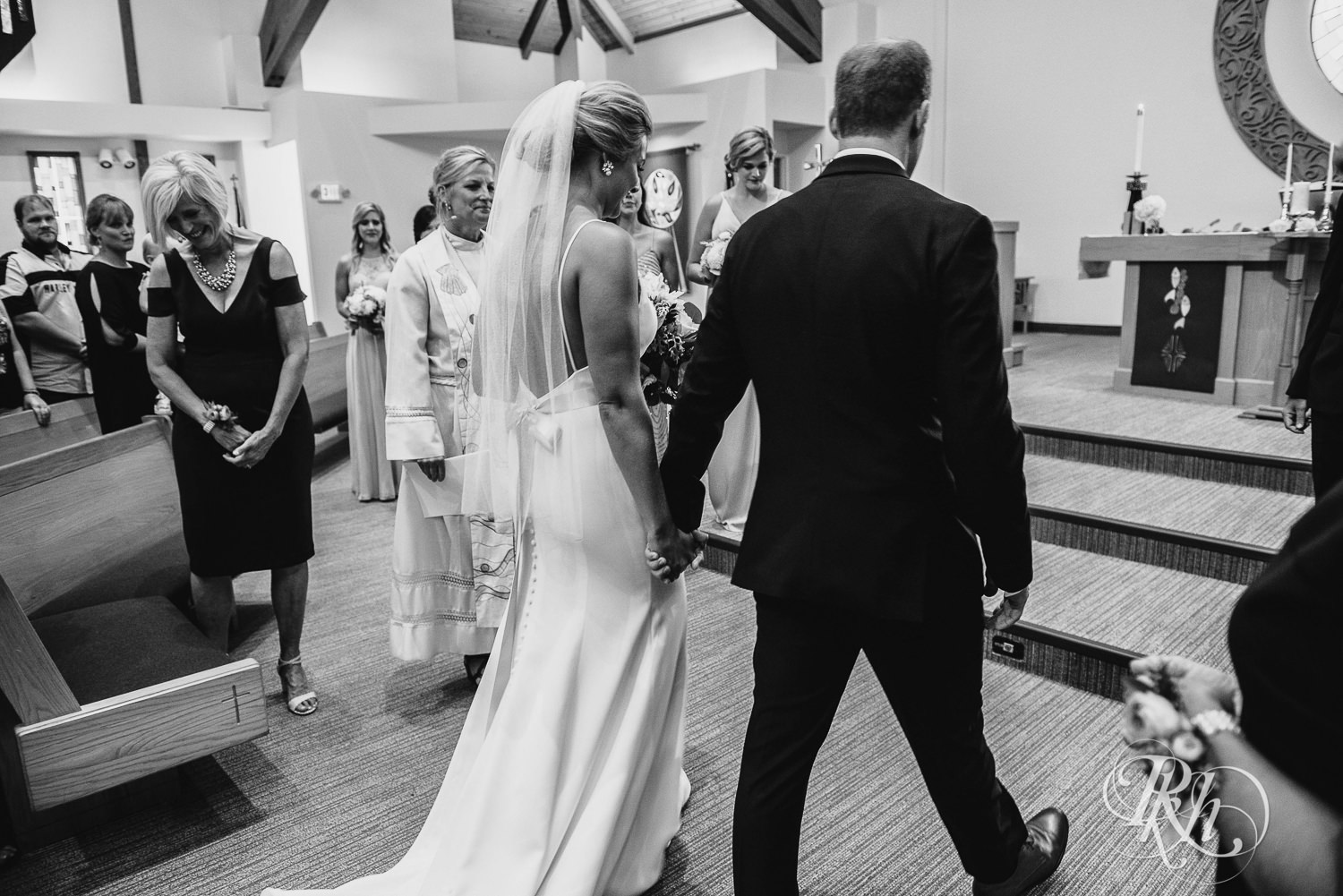 Bride and groom hold hands during a church wedding ceremony in Minneapolis, Minnesota.