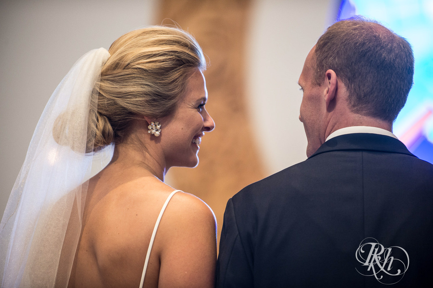 Bride and groom smile during a church wedding ceremony in Minneapolis, Minnesota.