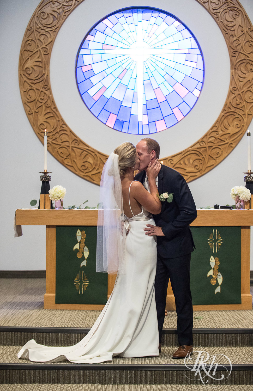 Bride and groom kiss during a church wedding ceremony in Minneapolis, Minnesota.