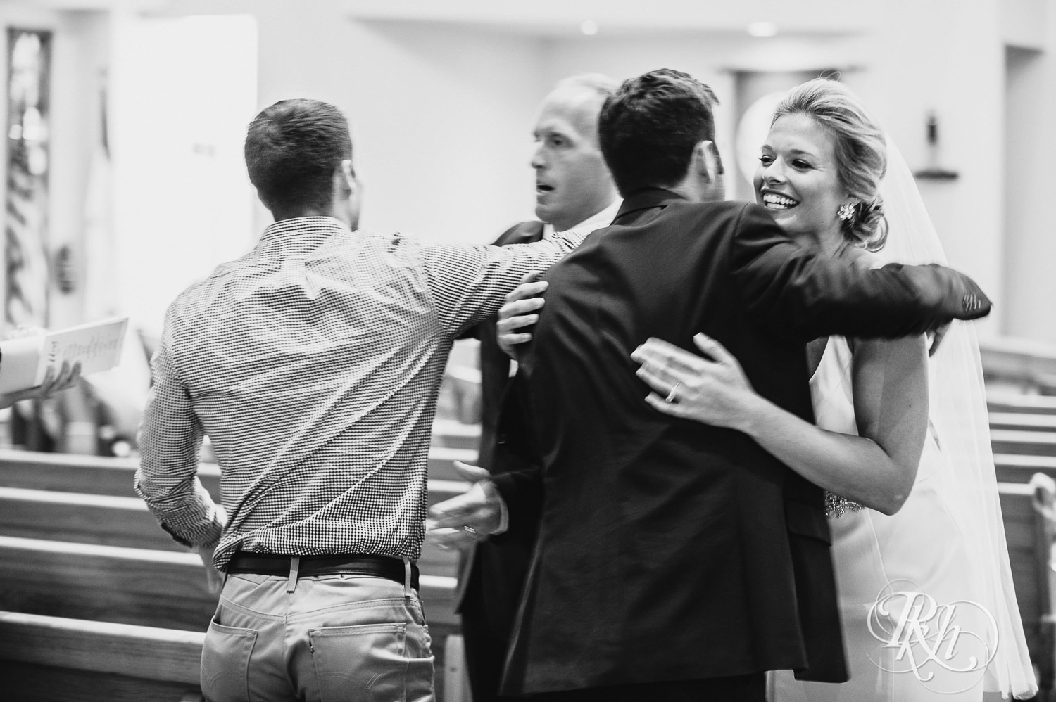 Bride and groom hug guests after a church wedding ceremony in Minneapolis, Minnesota.