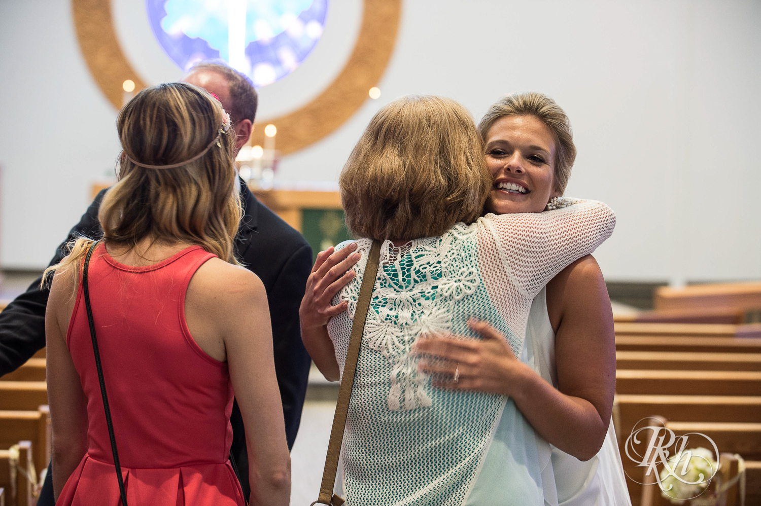 Bride and groom hug guests after a church wedding ceremony in Minneapolis, Minnesota.