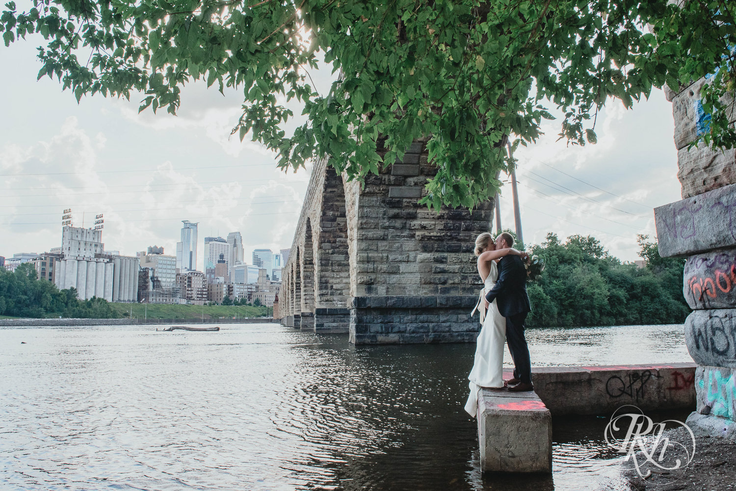 Bride and groom kiss under a bridge on their wedding day in Minneapolis, Minnesota.