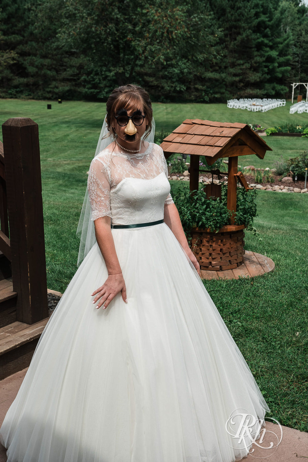 Bride wears a Groucho Marx mask for first look on wedding day in Elk Mound, Wisconsin.