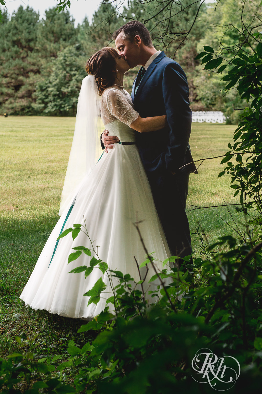 Bride and groom kiss in the woods on wedding day in Elk Mound, Wisconsin.