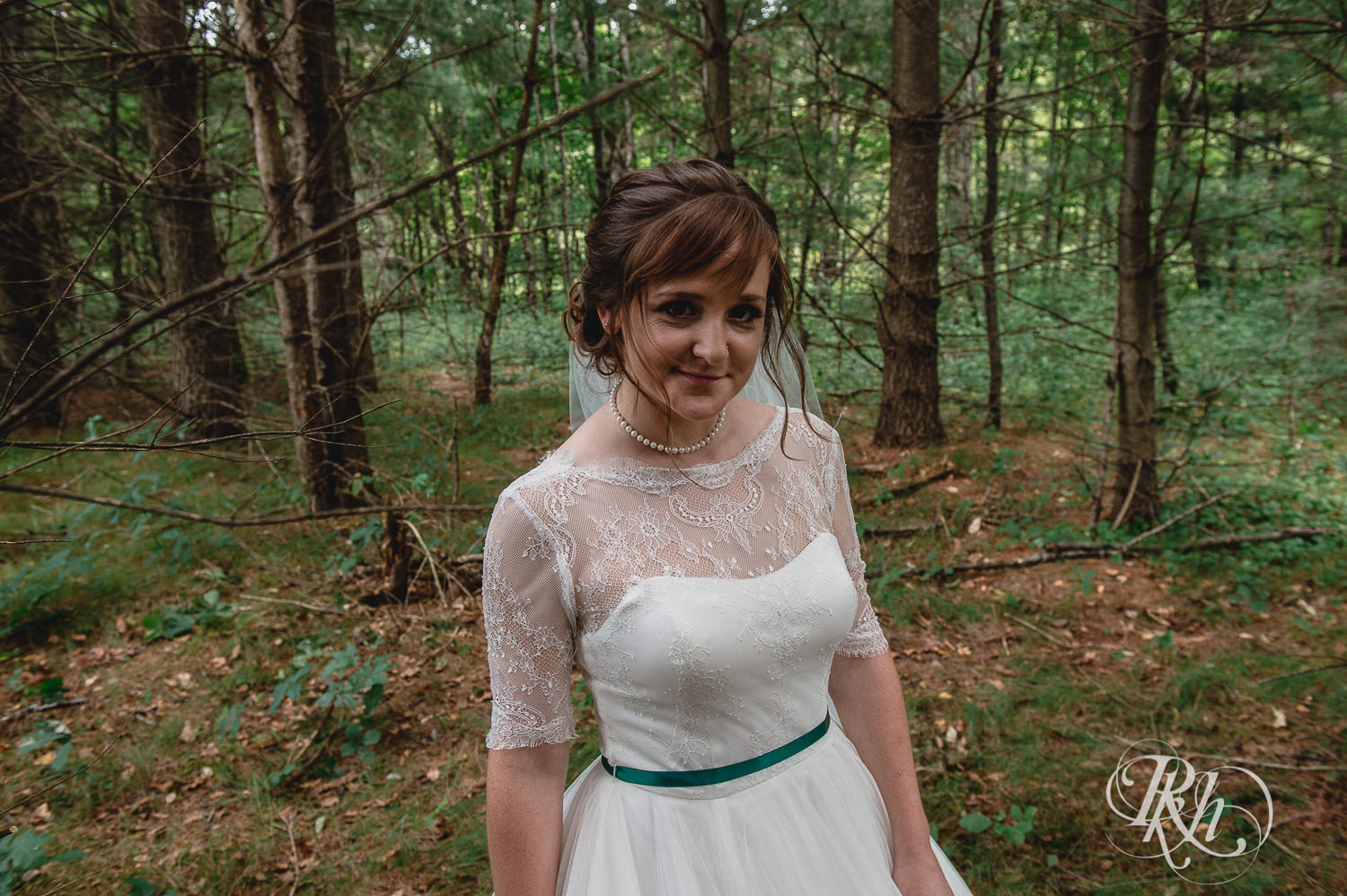 Bride smiles in the woods on wedding day in Elk Mound, Wisconsin.