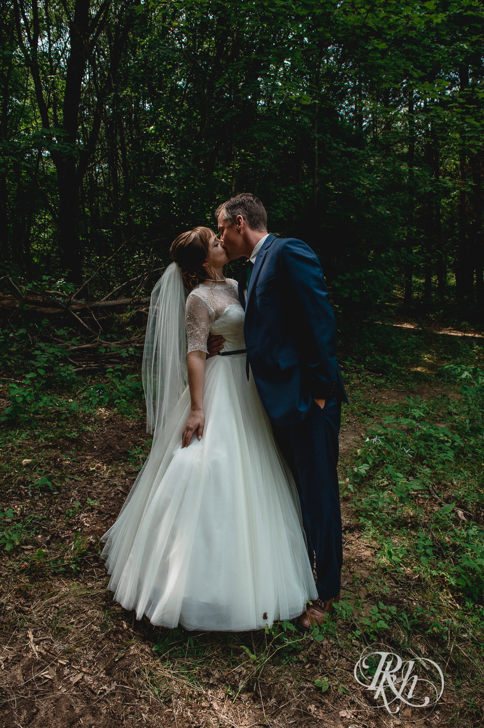 Bride and groom kiss in the woods on wedding day in Elk Mound, Wisconsin.