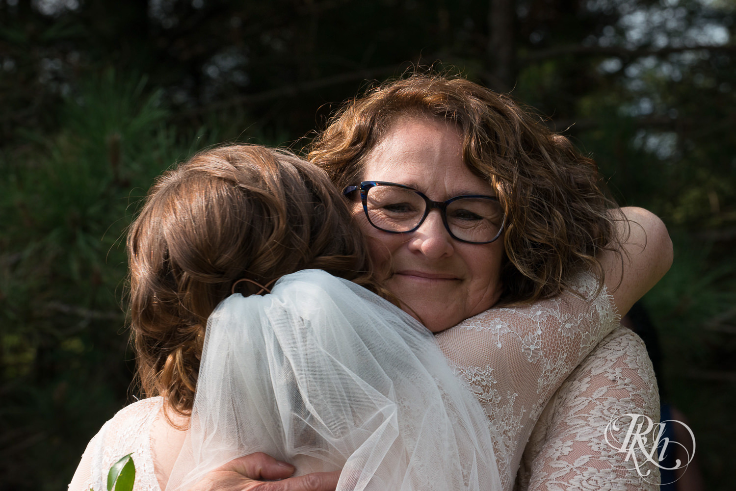 Mom hugs bride during outdoor wedding ceremony in Elk Mound, Wisconsin.
