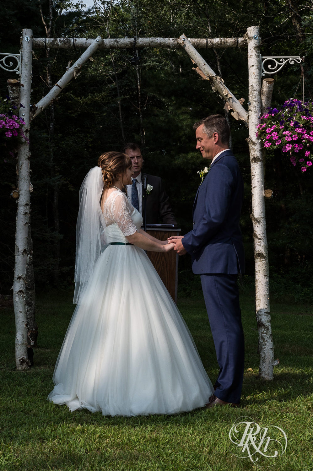 Bride and groom smile during outdoor wedding ceremony in Elk Mound, Wisconsin.