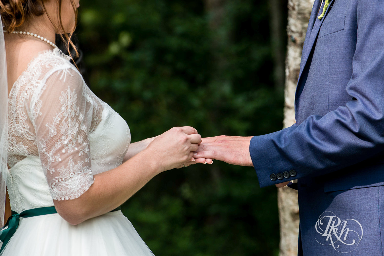 Bride and groom exchange rings during outdoor wedding ceremony in Elk Mound, Wisconsin.