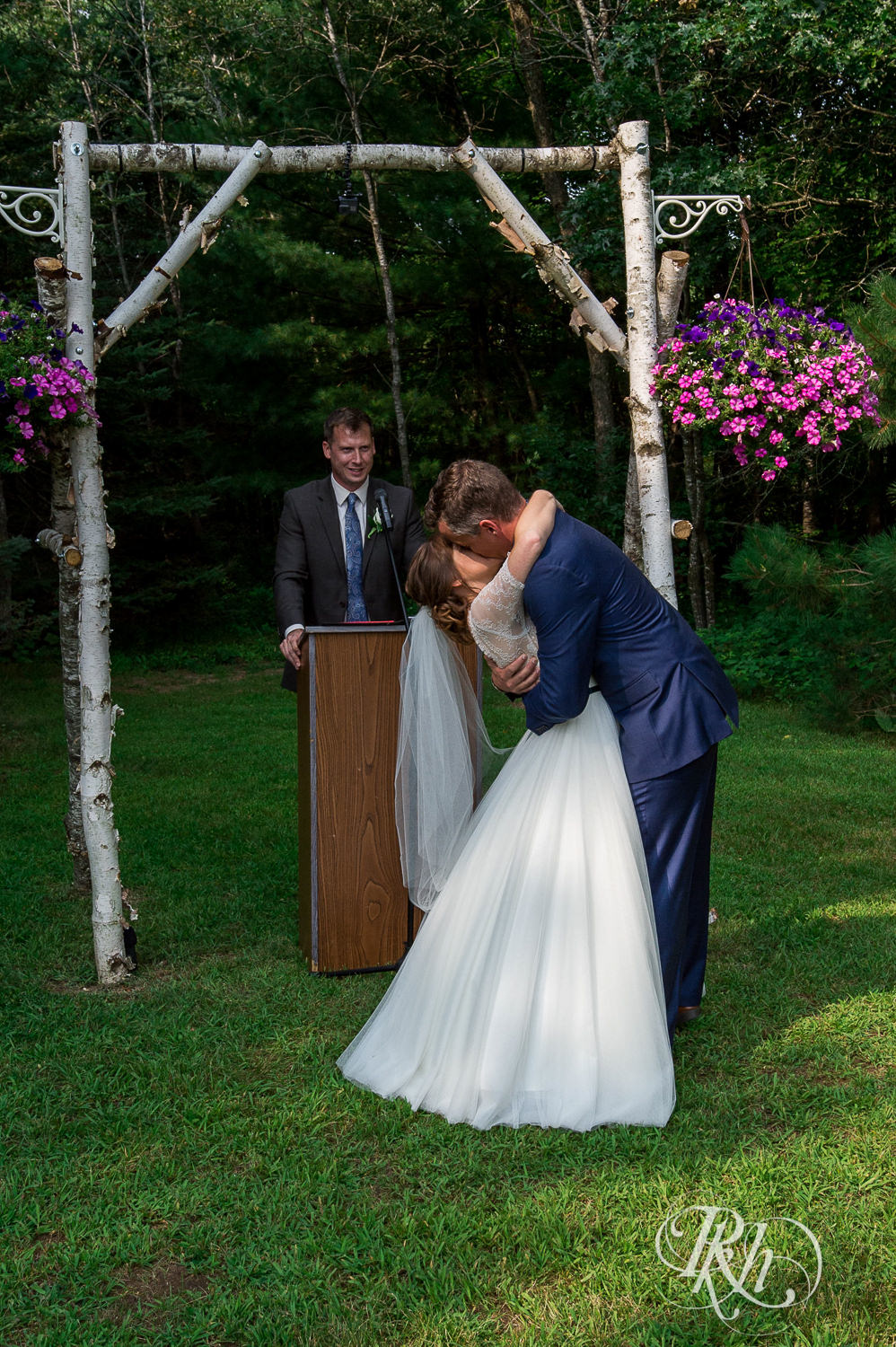 Bride and groom kiss during outdoor wedding ceremony in Elk Mound, Wisconsin.