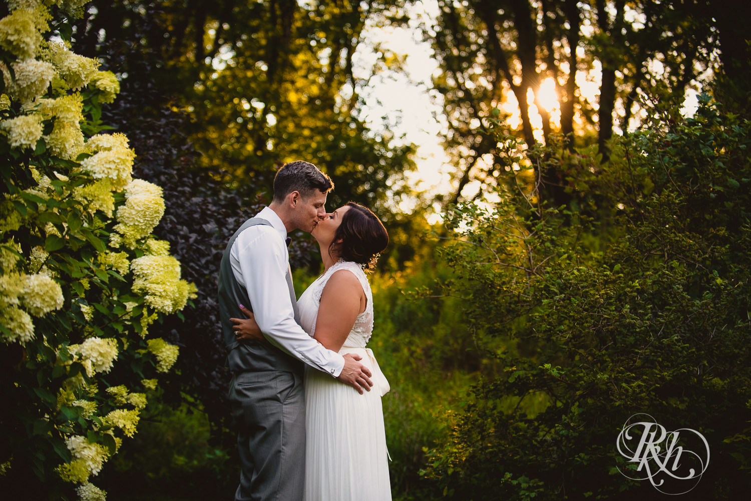 Bride and groom kiss during sunset at Camrose Hill Flower Farm in Stillwater, Minnesota.