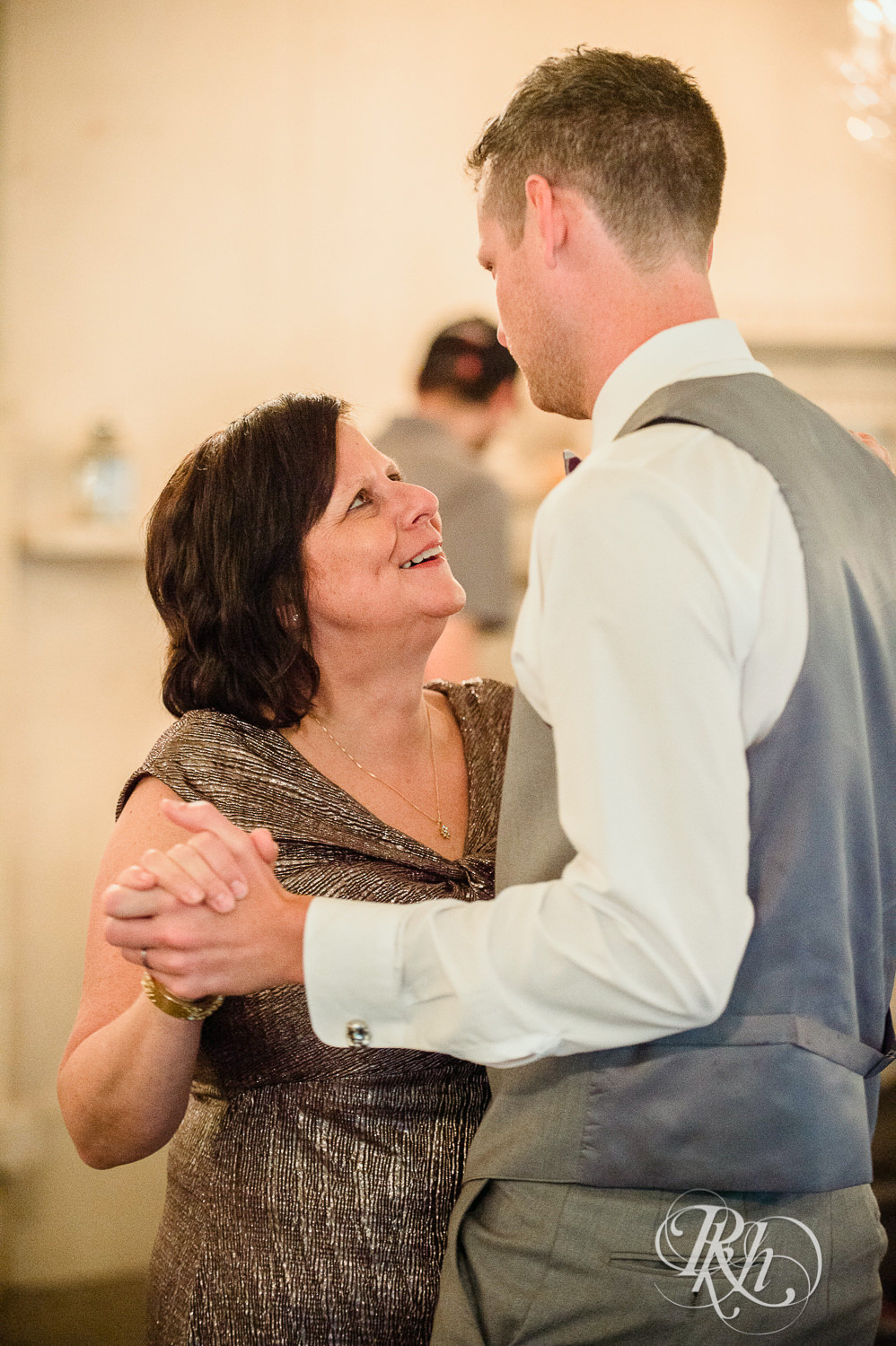 Groom and his mom dance during wedding reception at Camrose Hill Flower Farm in Stillwater, Minnesota.