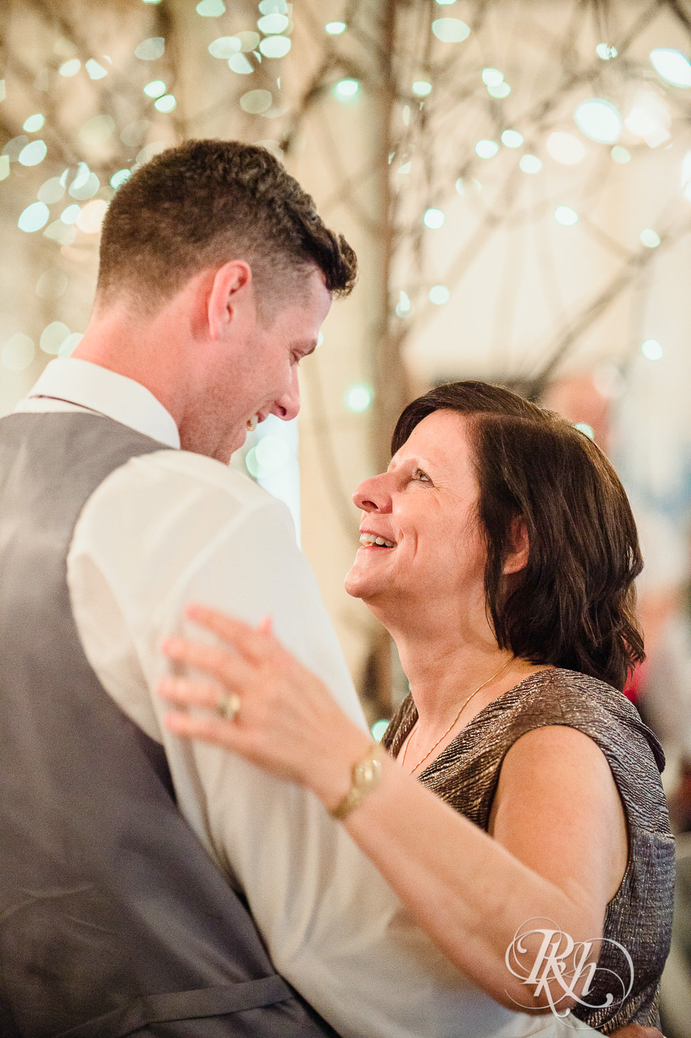 Groom and his mom dance during wedding reception at Camrose Hill Flower Farm in Stillwater, Minnesota.