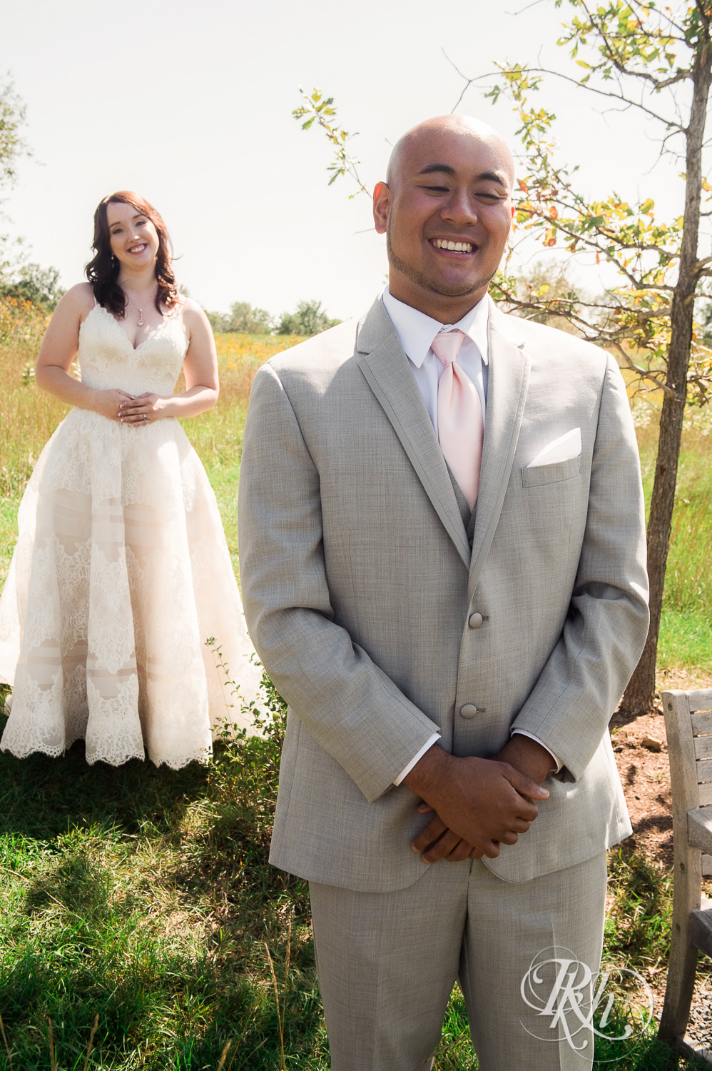 Asian groom and bride doing first look on a hill at Birch Hill Barn in Glenwood City, Wisconsin.