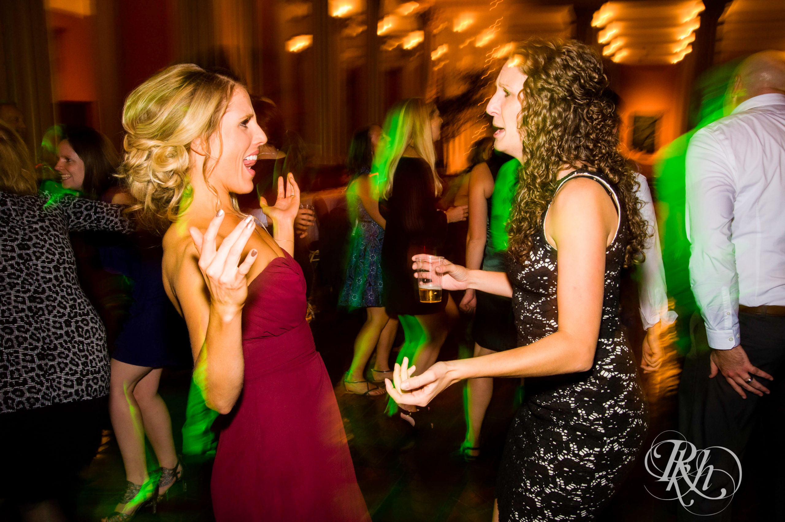 Guests dance during wedding reception on wedding day at Landmark Center in Saint Paul, Minnesota.