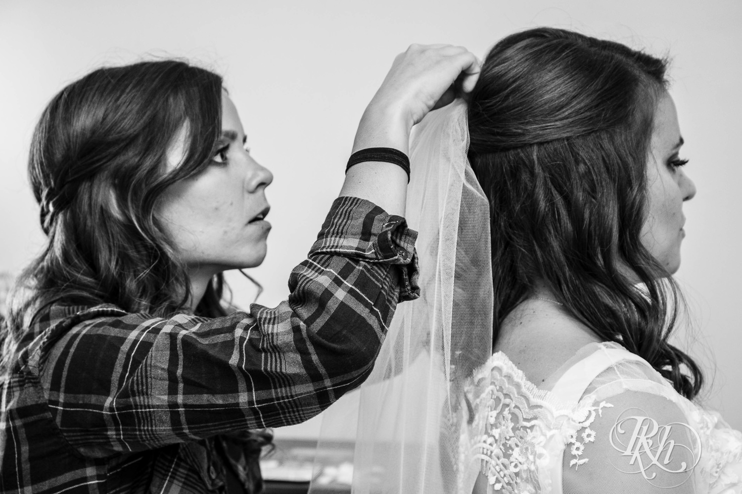 Bridesmaids help bride with her veil on her wedding day in her childhood home in Saint Paul, Minnesota.