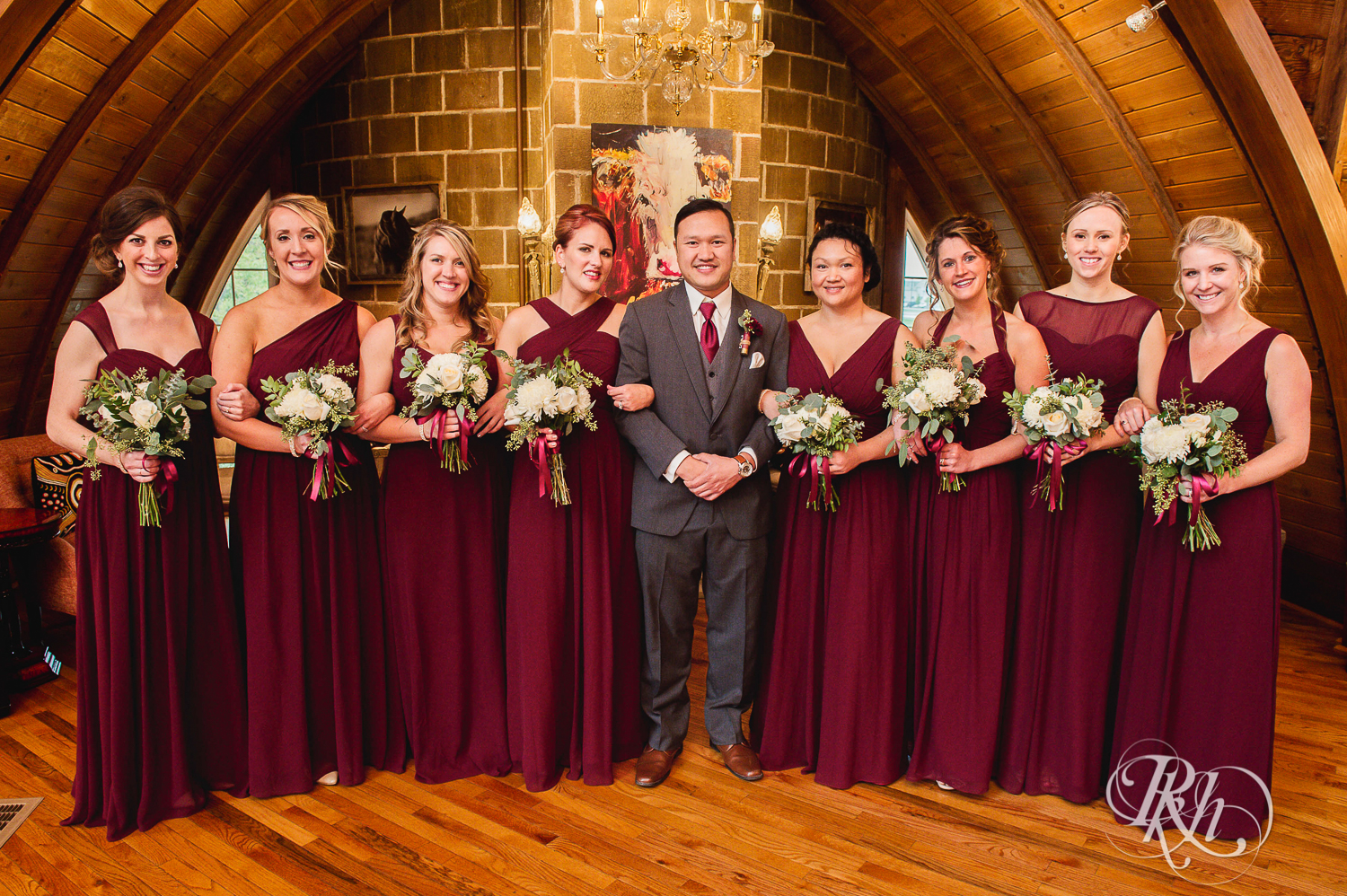 Groom smiles with wedding party at Green Acres Event Center barn wedding in Eden Prairie, Minnesota.