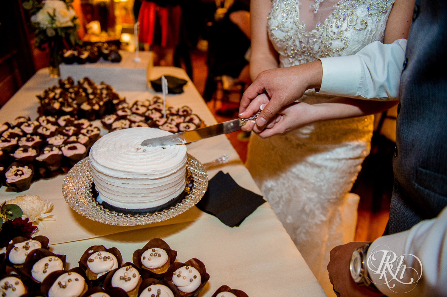 Bride and groom cut wedding cake at Green Acres Event Center barn wedding in Eden Prairie, Minnesota.