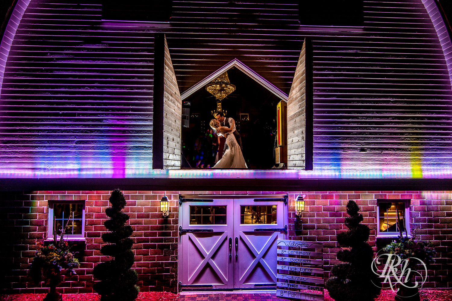 Bride and groom kiss at night at Green Acres Event Center barn wedding in Eden Prairie, Minnesota.