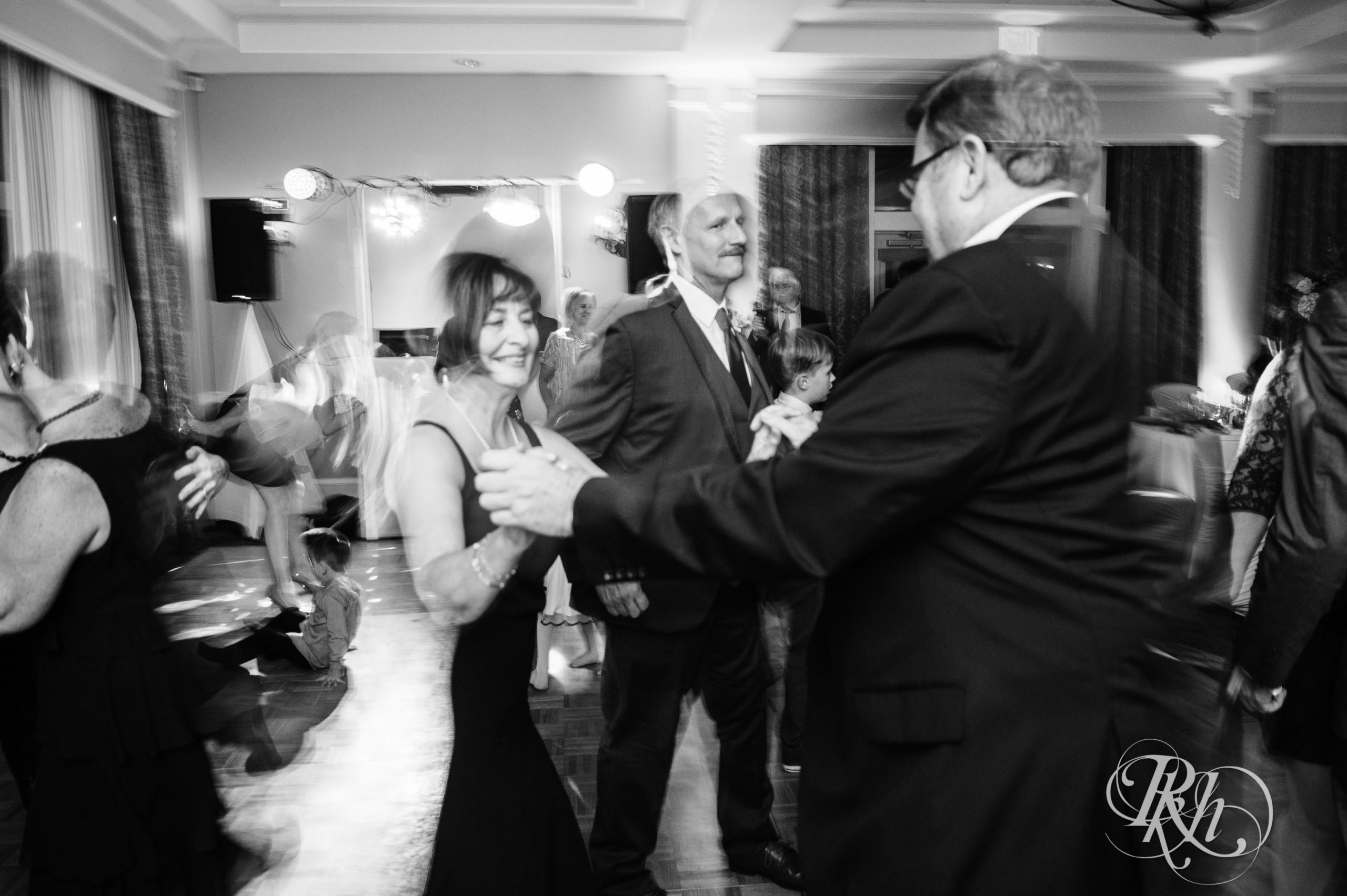 Bride dances with guests on fall wedding day at Minneapolis Golf Club in Minneapolis, Minnesota.