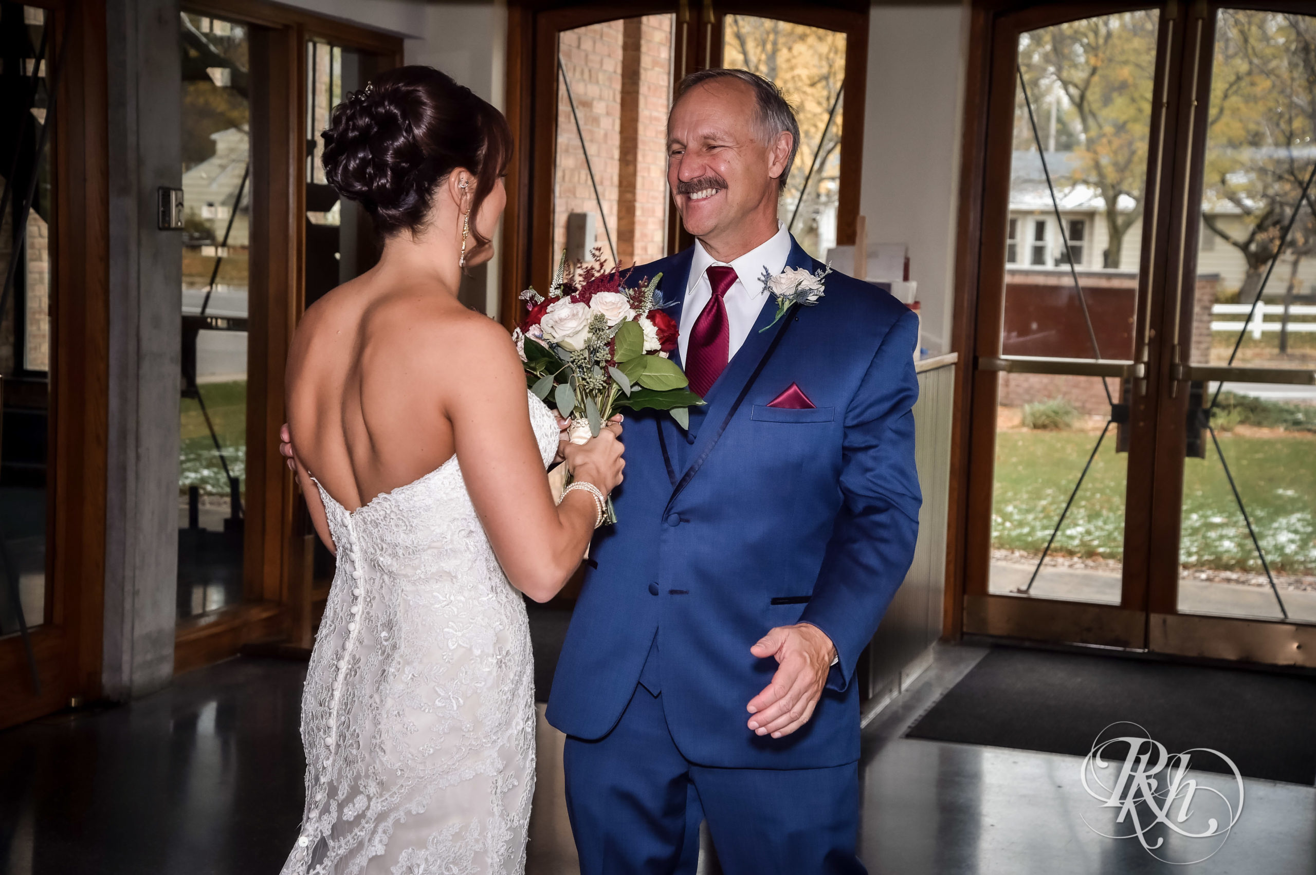 Bride laughing with dad at church before wedding ceremony in Minneapolis, Minnesota.