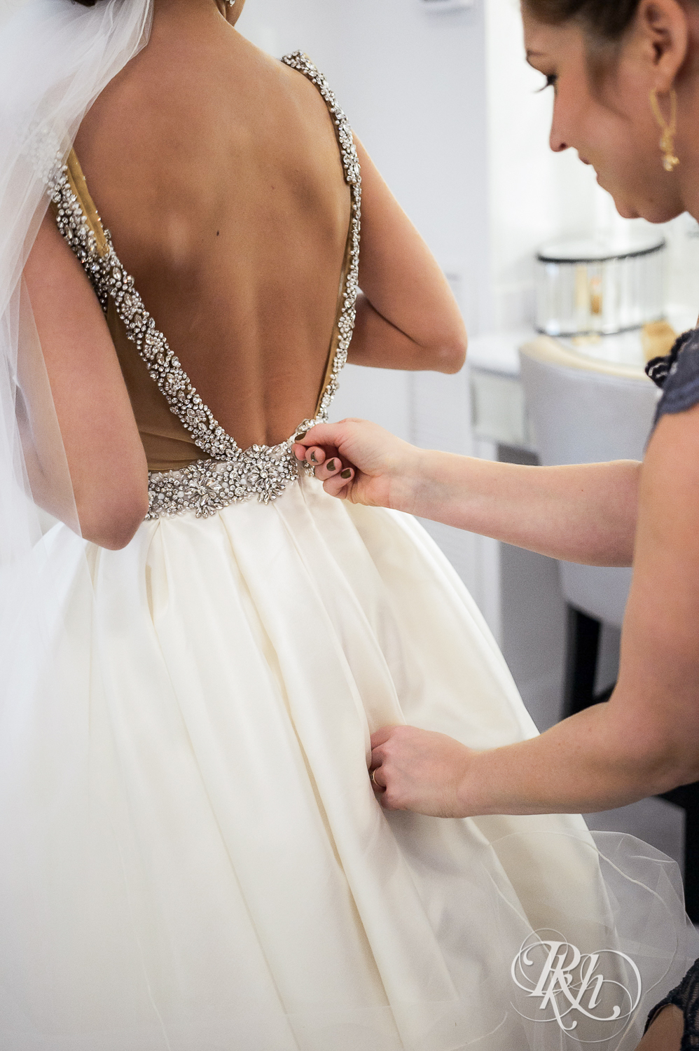 Bride getting zipped into wedding dress at The Saint Paul Hotel in Saint Paul, Minnesota.
