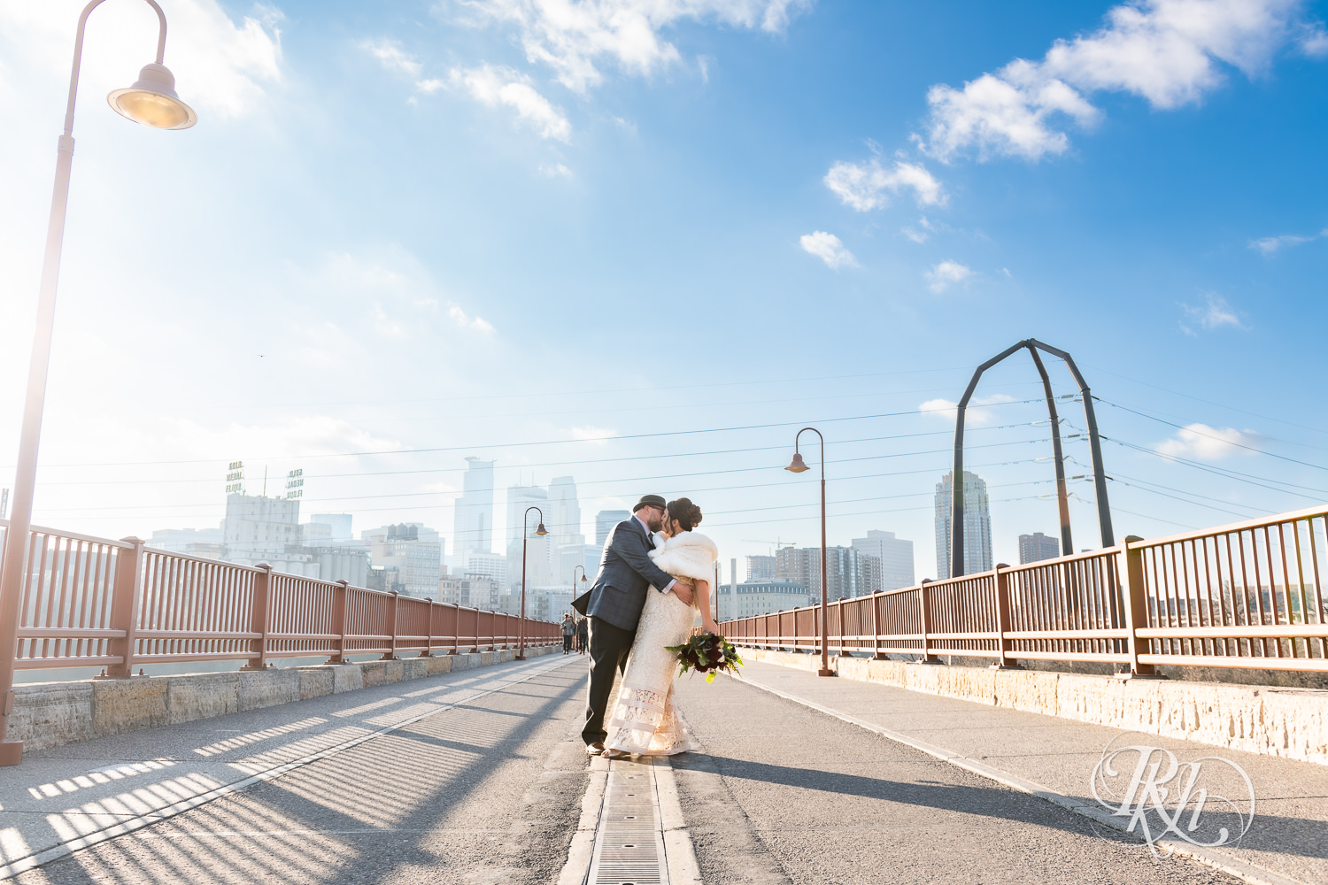 Bride and groom kiss on Stone Arch Bridge in Minneapolis, Minnesota.