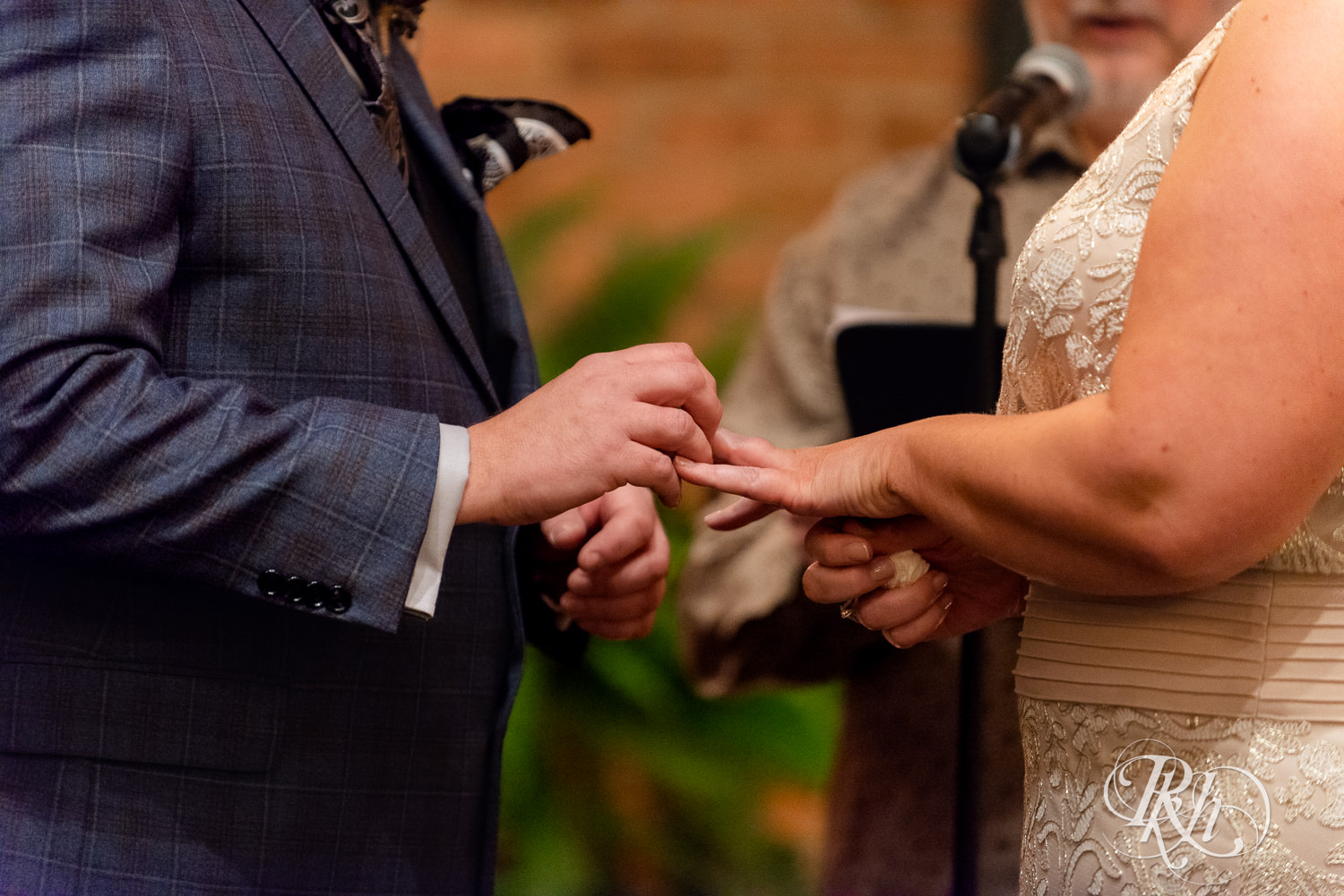 Bride and groom exchange rings during wedding ceremony at Nicollet Island Pavilion in Minneapolis, Minnesota.