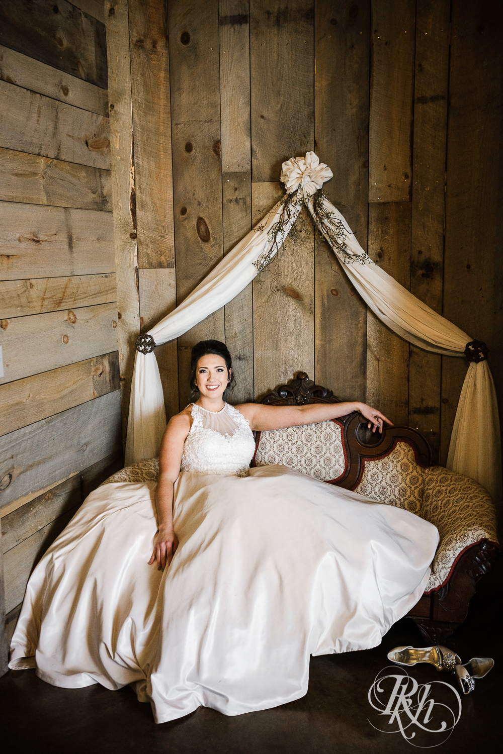 Bride smiles sitting on couch during winter wedding at Creekside Farm in Rush City, Minnesota.