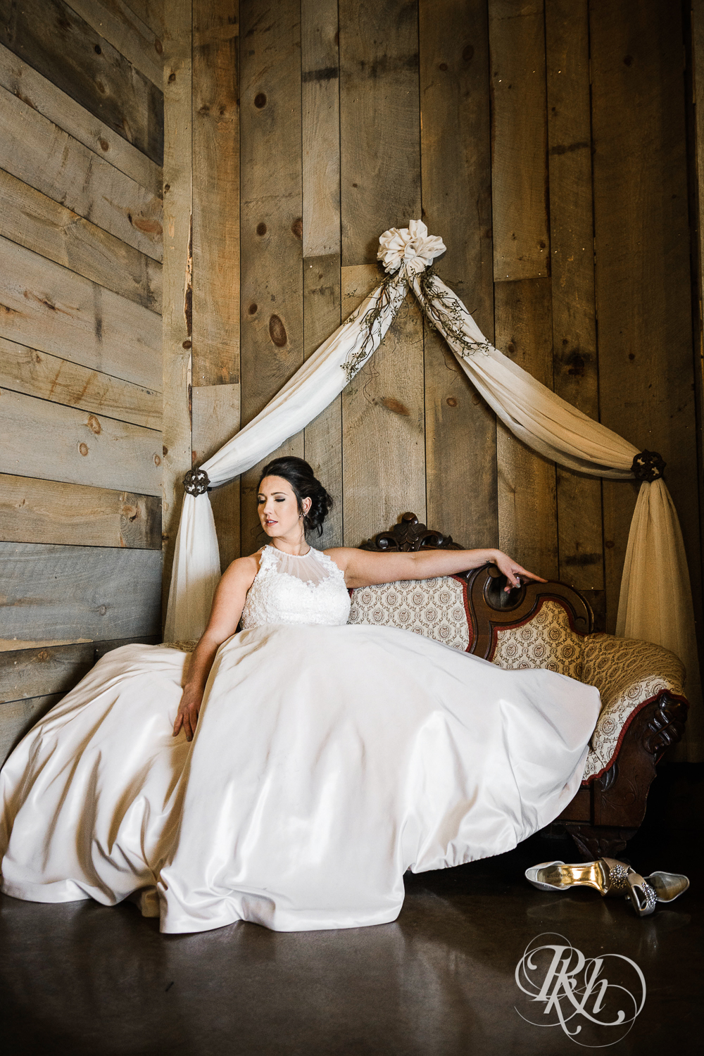 Bride smiles sitting on couch during winter wedding at Creekside Farm in Rush City, Minnesota.