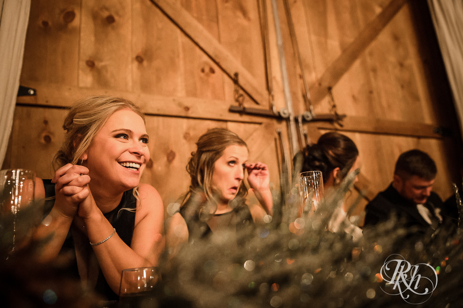 Wedding party laughs during wedding reception speeches at Creekside Farm in Rush City, Minnesota.