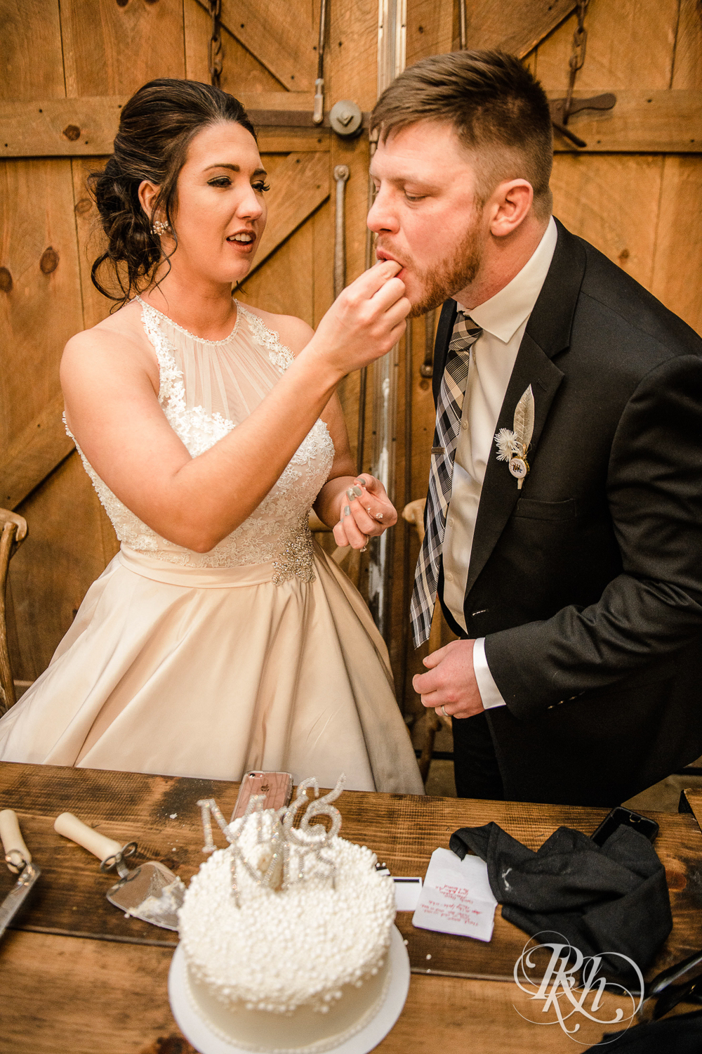 Bride and groom cut wedding cake during reception at Creekside Farm in Rush City, Minnesota.