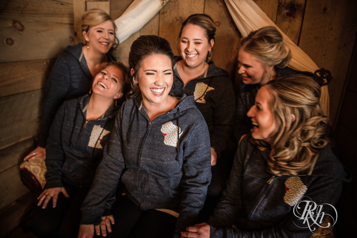 Bridesmaids laugh with bride before wedding at Creekside Farm in Rush City, Minnesota.