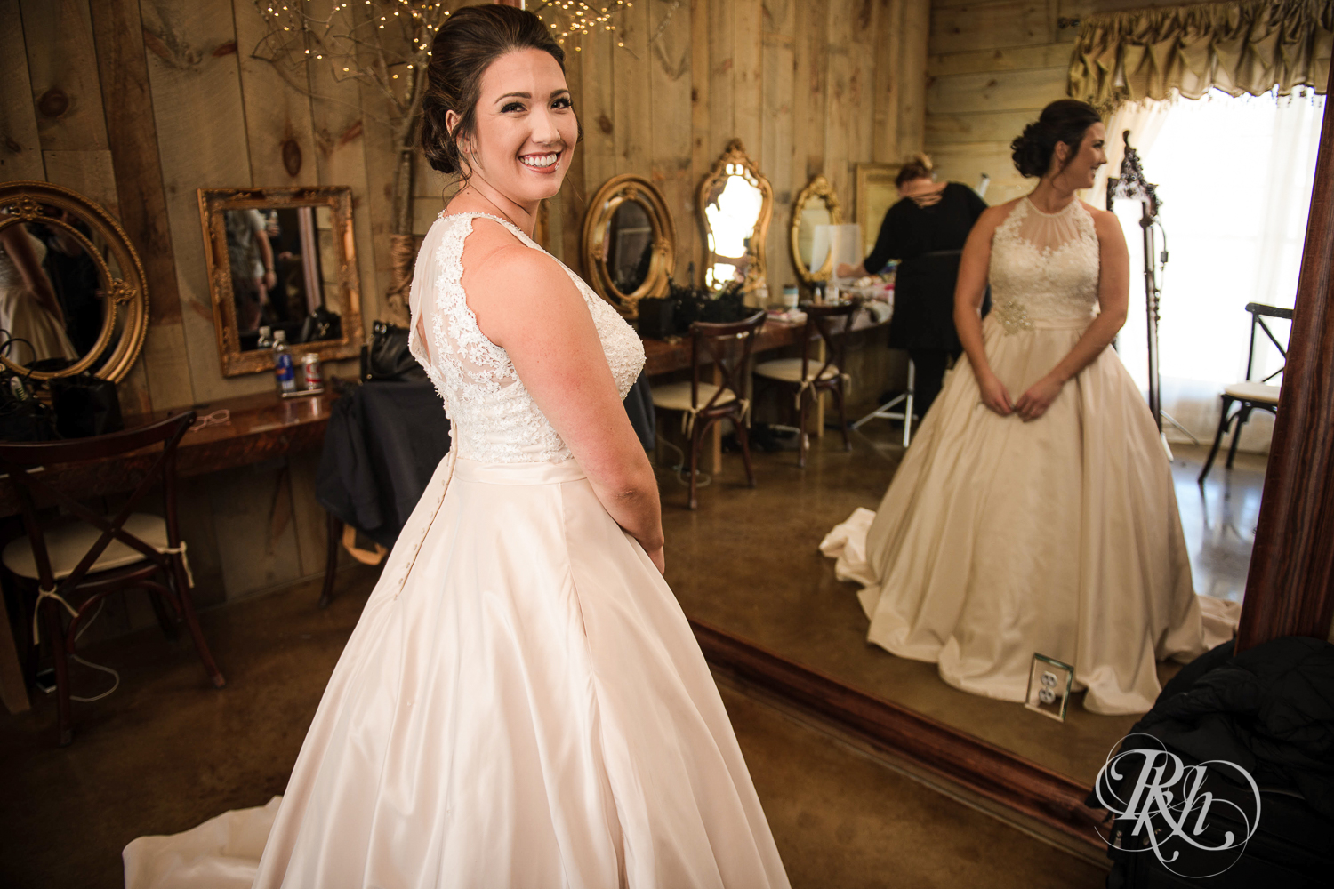 Bride gets into wedding dress before wedding at Creekside Farm in Rush City, Minnesota.