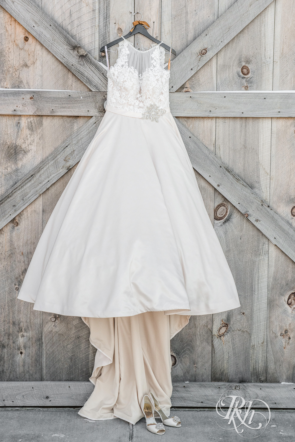 Wedding dress hanging on barn door with shoes at Creekside Farm in Rush City, Minnesota.