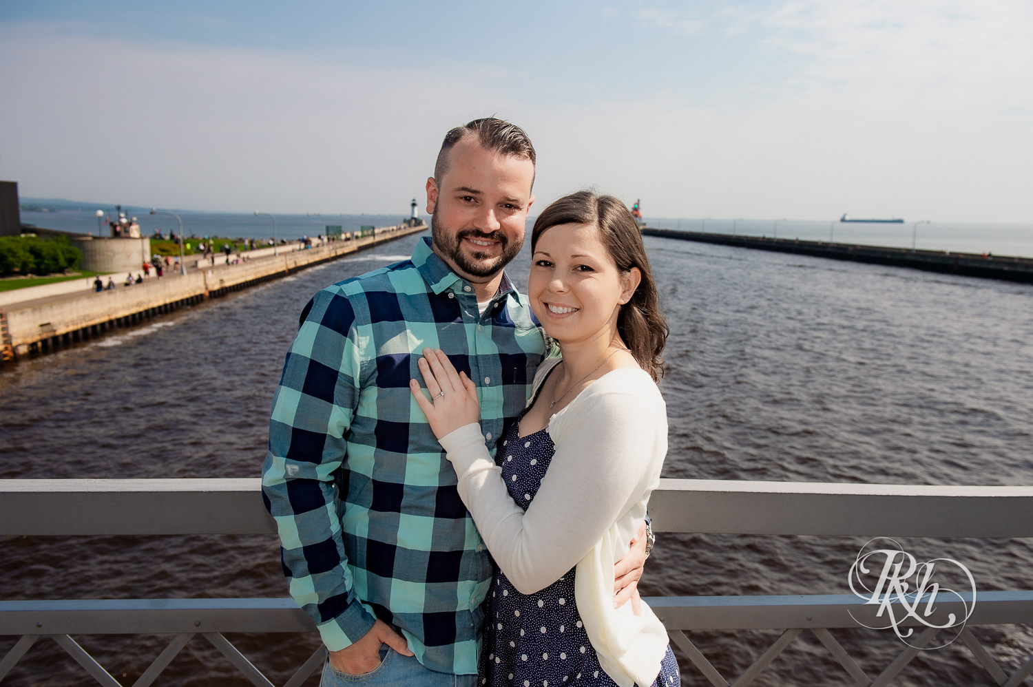 Man and woman smile with Lake Superior in the background in Duluth, Minnesota.