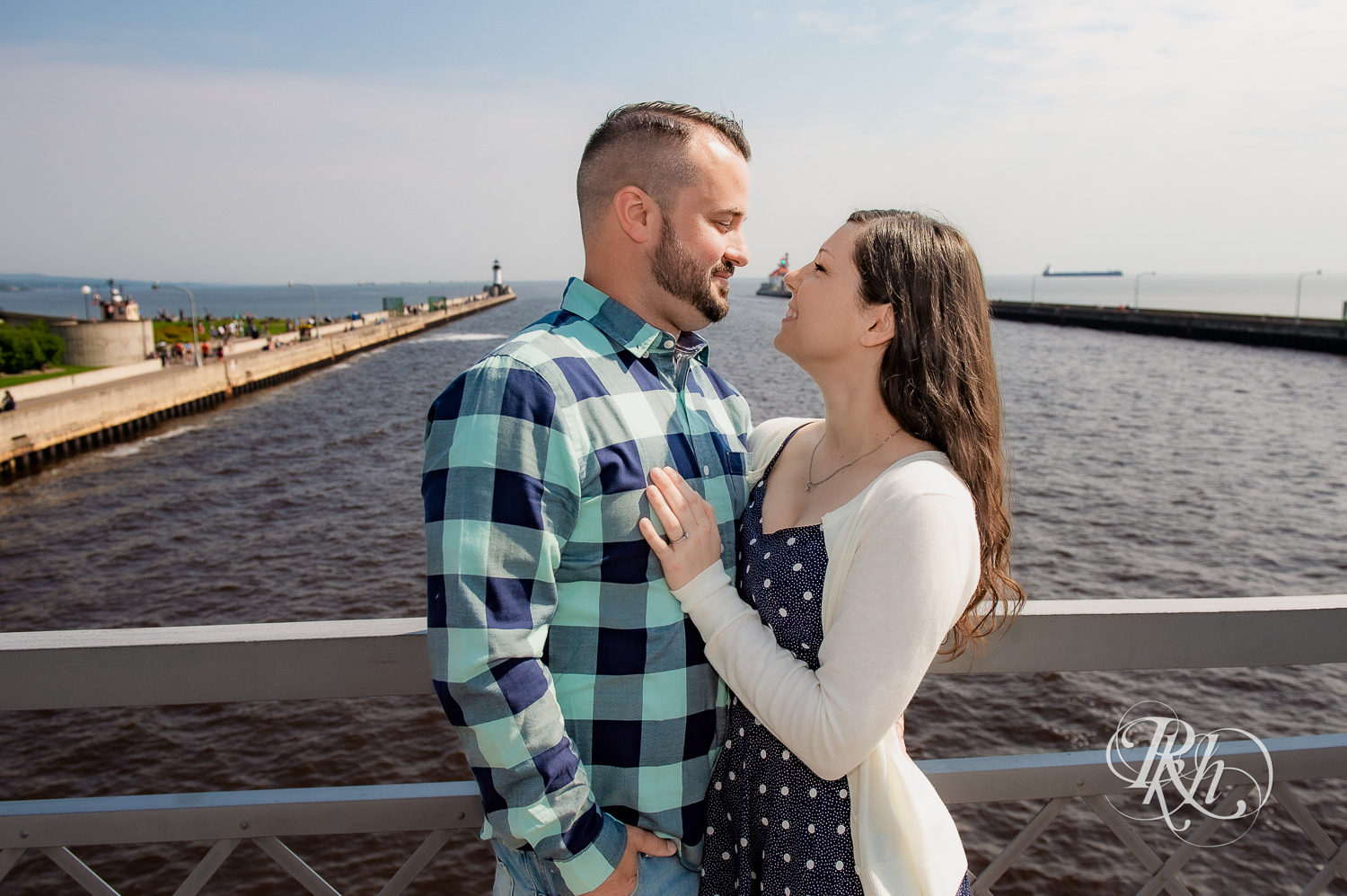 Man and woman smile with Lake Superior in the background in Duluth, Minnesota.