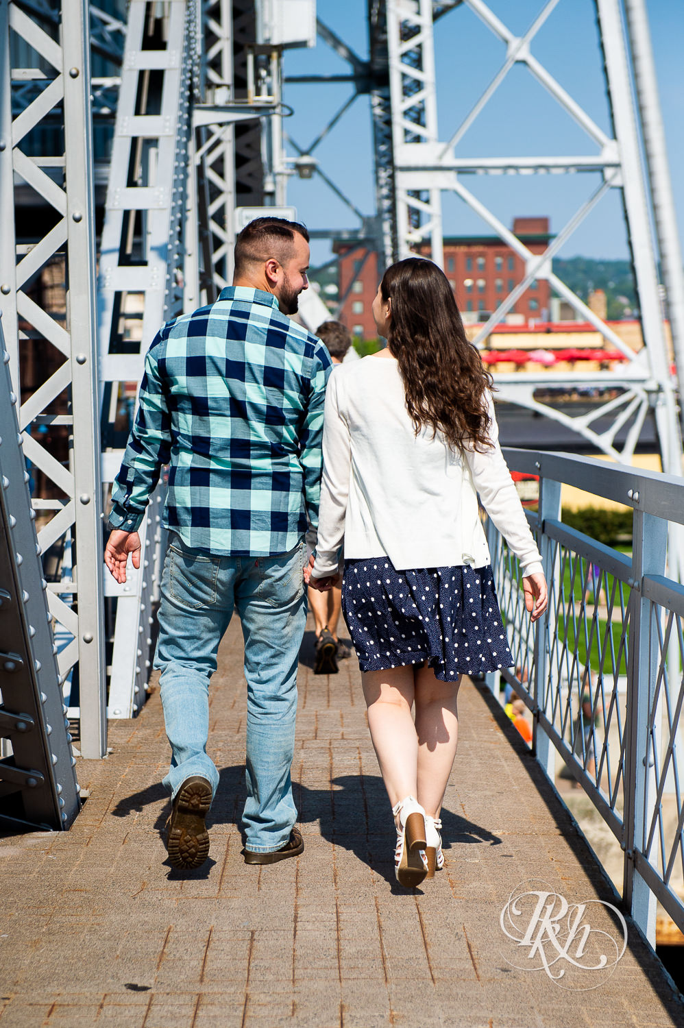 Man and woman walk holding hands in Canal Park in Duluth, Minnesota.