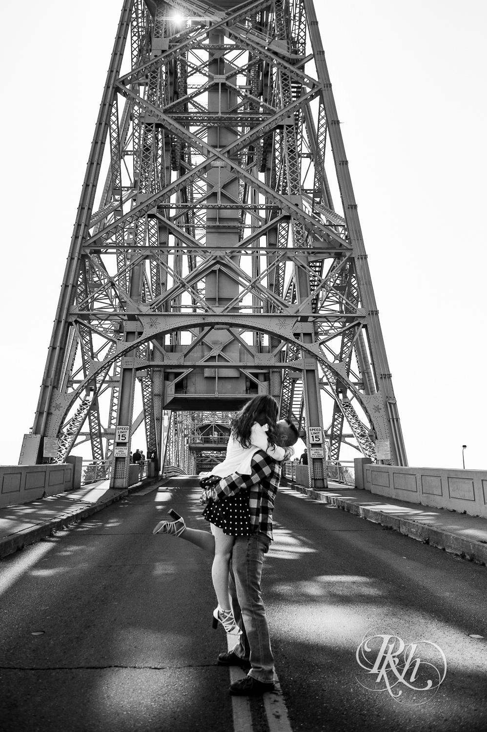 Man and woman kiss in front of bridge in Canal Park in Duluth, Minnesota.