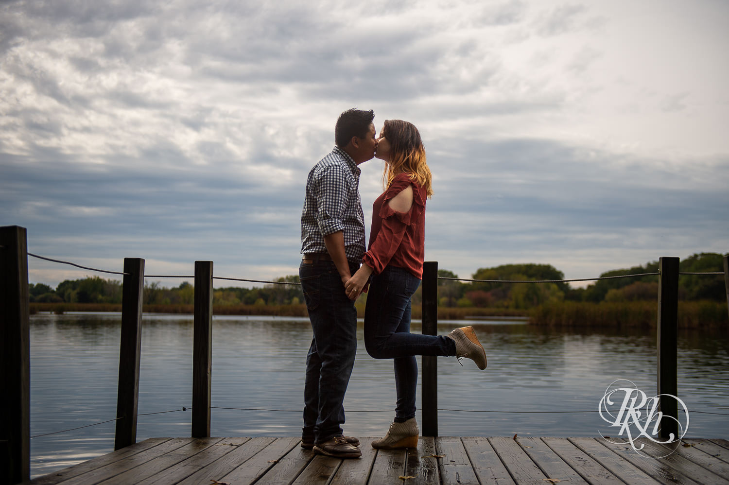 Asian man and woman kiss at Wood Lake Nature Center in Richfield, Minnesota.