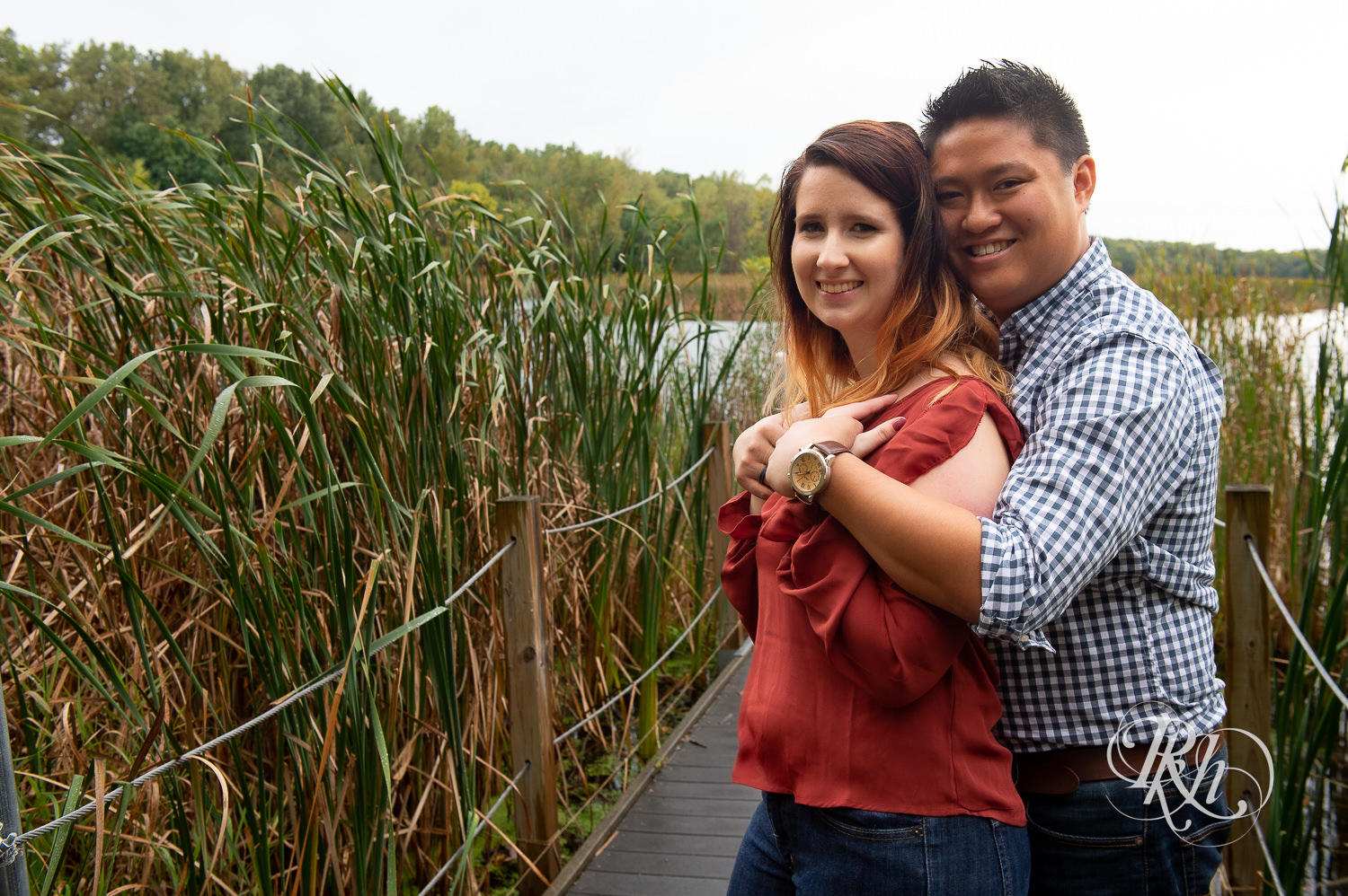 Asian man and woman smile on a dock at Wood Lake Nature Center in Richfield, Minnesota.