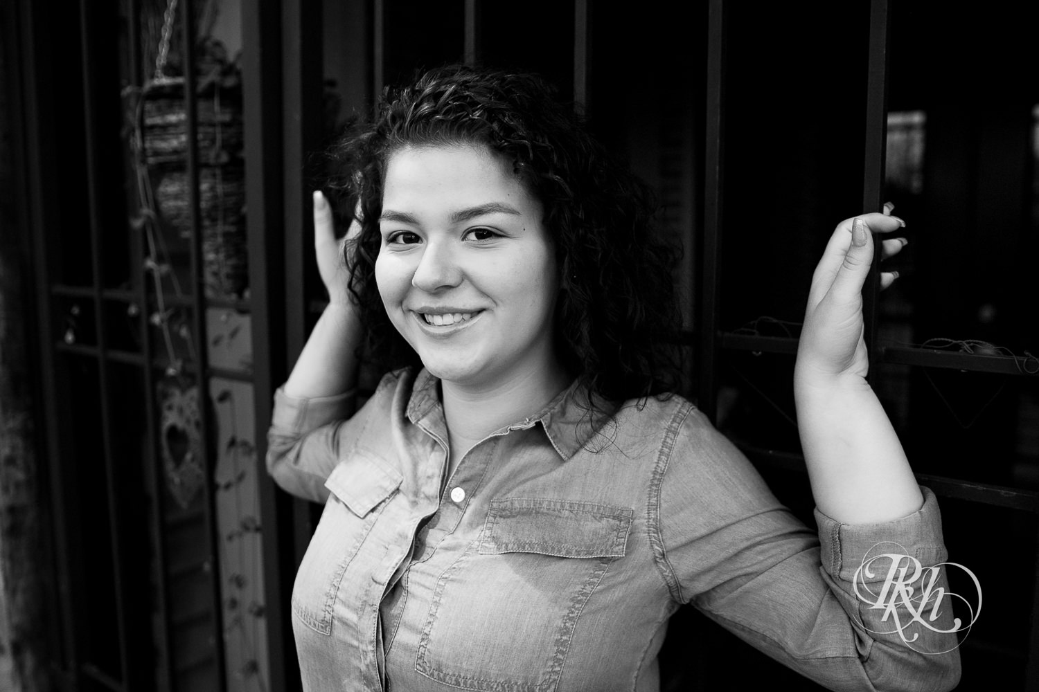 Senior girl with curly hair smiles for Minneapolis senior pictures at Mill City Ruins.