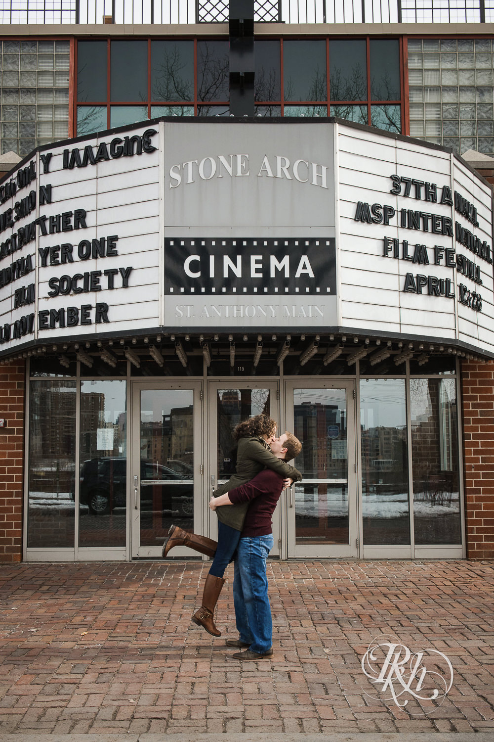 Man kisses woman in front of the Stone Arch Cinema in Minneapolis, Minnesota.