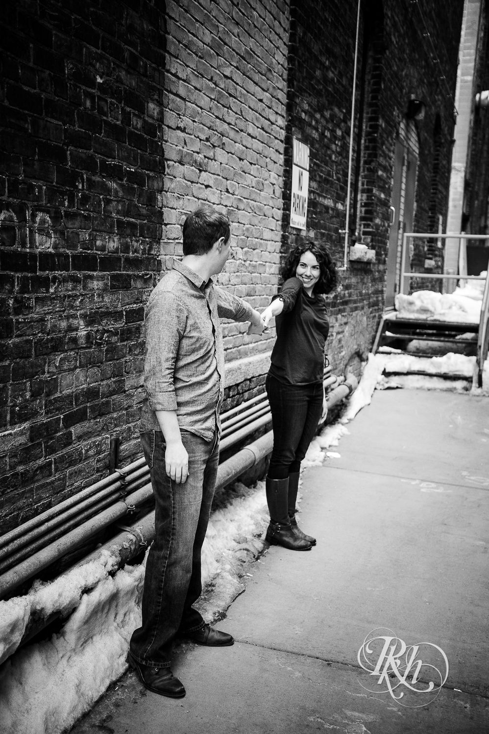 Man and woman smile in front of brick while in Minneapolis, Minnesota.