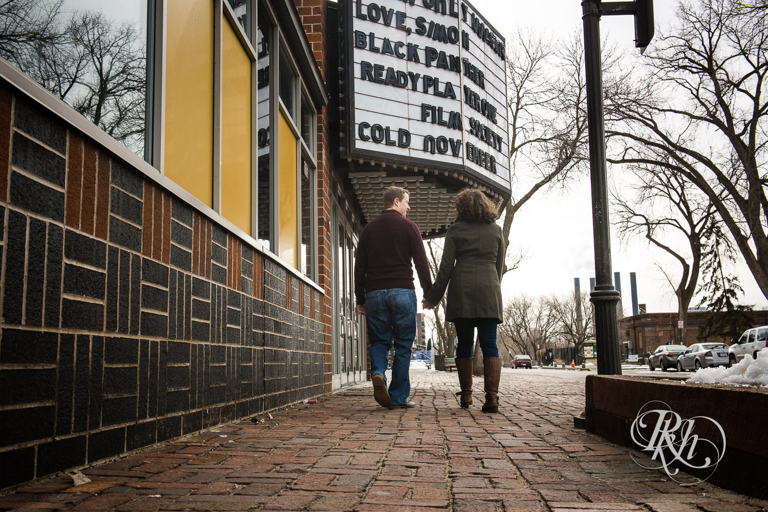 Man walks with woman in front of the Stone Arch Cinema in Minneapolis, Minnesota.
