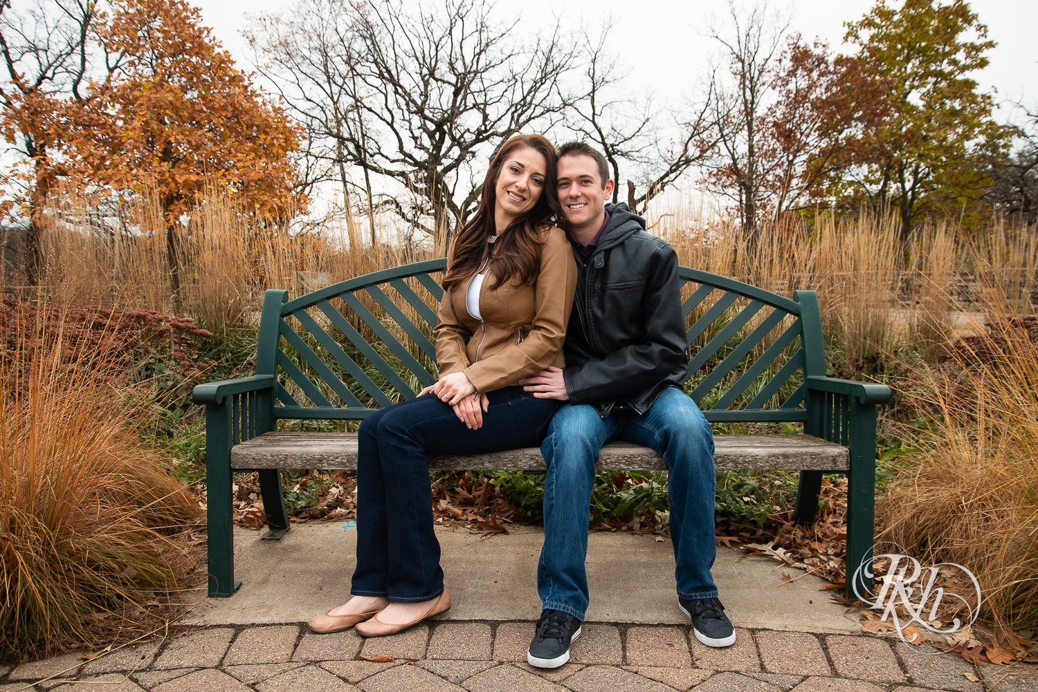 Man and woman cuddle on a bench in Minnehaha Falls in Minneapolis, Minnesota.