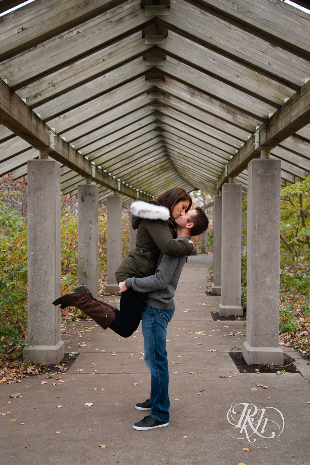 Man lifts and kisses woman in Minnehaha Falls in Minneapolis, Minnesota.
